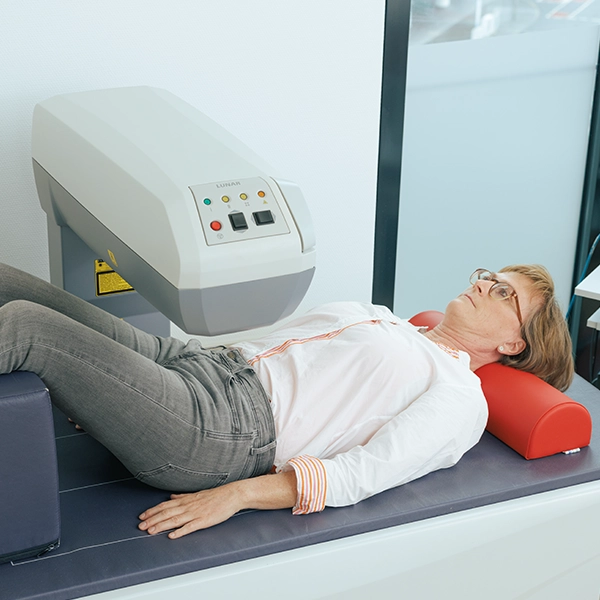 Frau wird in der orthopädischen Praxis mit einem medizinischen Gerät zur Behandlung von Rückenbeschwerden therapiert.