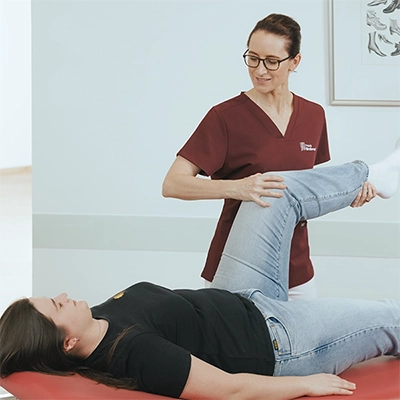 Frau Dr. Limbrock bewegt das Bein einer Patientin im Rahmen einer orthopädischen Untersuchung auf einer Behandlungsliege.