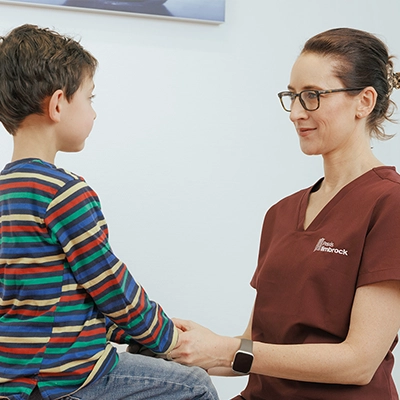 Orthopädin Frau Dr. Limbrock überprüft die Beweglichkeit des Arms eines Kindes während einer Untersuchung.