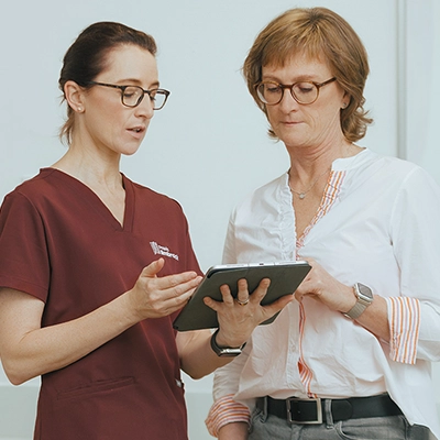 Orthopädin Frau Dr. Limbrock erklärt einer Patientin präventive Maßnahmen anhand digitaler Befunde.